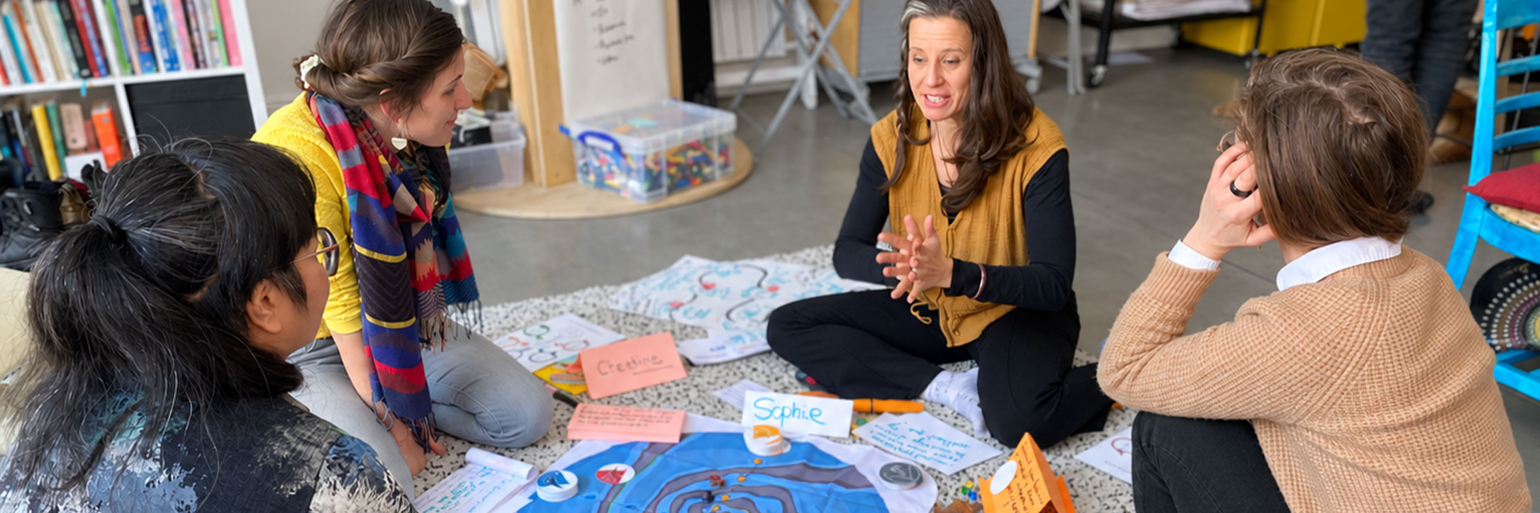 Participants gathered around a Flow Game board during a hosted session.