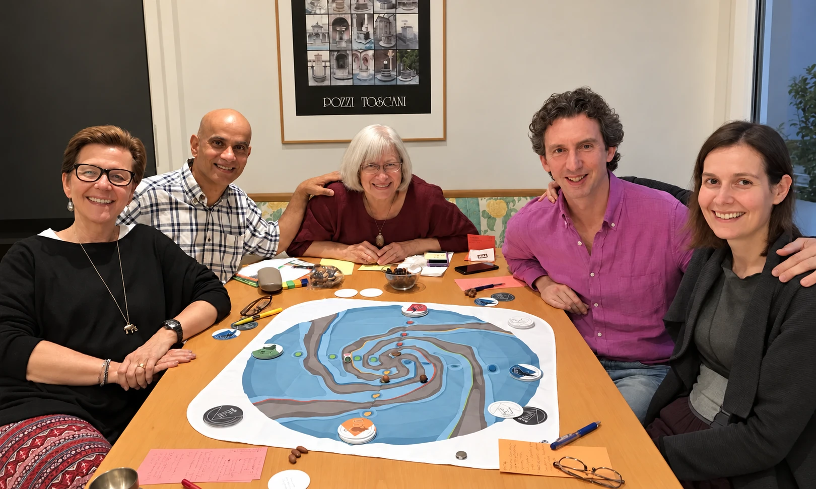 Five people gathered around the Flow Game cloth and cards